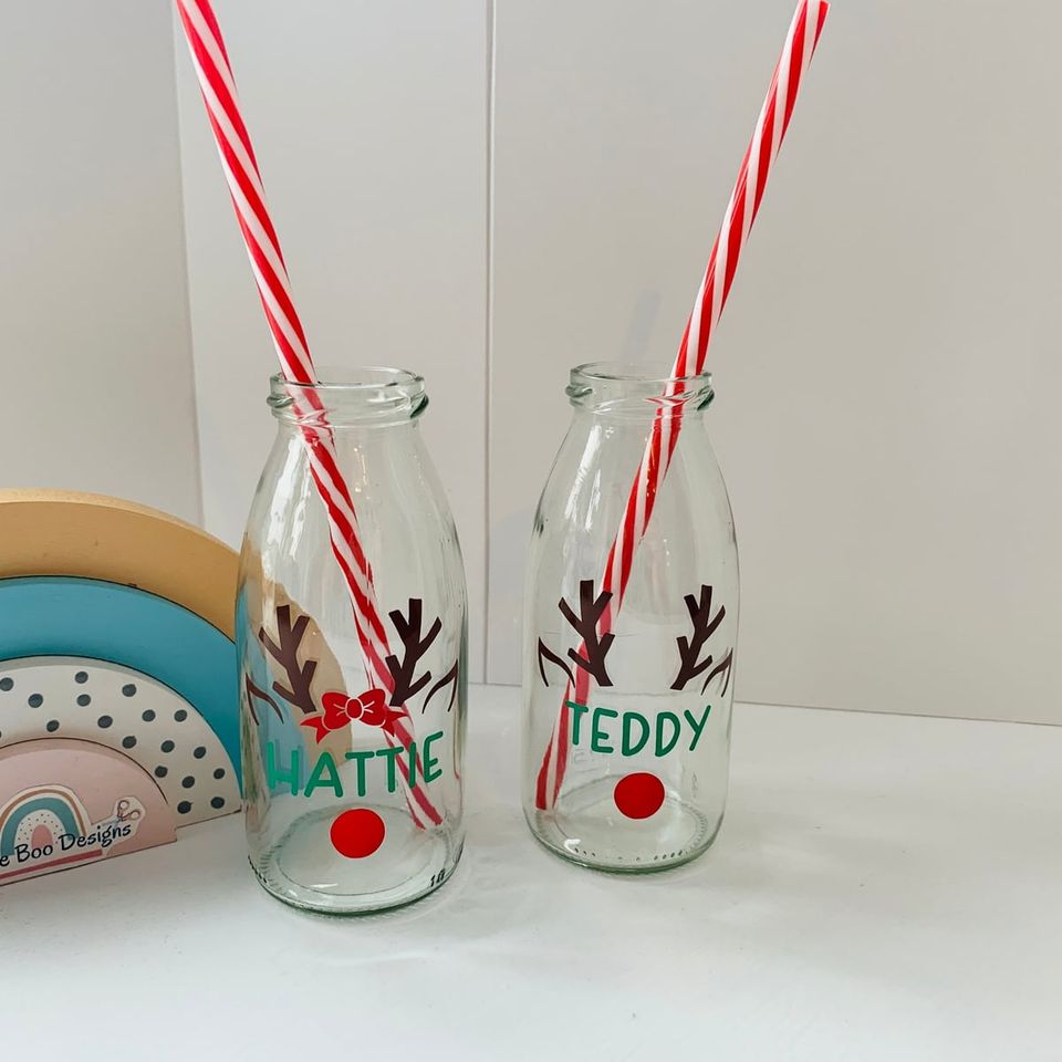 Two small glass milk bottles with reindeer antlers, red noses and the names “Hattie” and “Teddy”, with striped straws