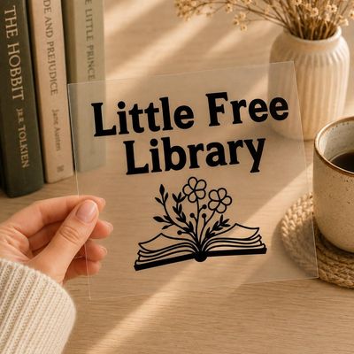 Clear vinyl decal reading “Little Free Library” with an open book and flowers