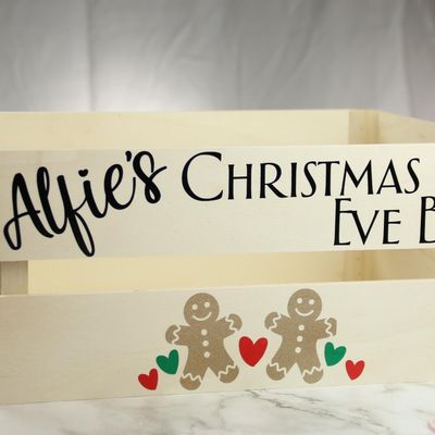 Wooden crate lettered “Alfie’s Christmas Eve Box” with gingerbread figures and hearts