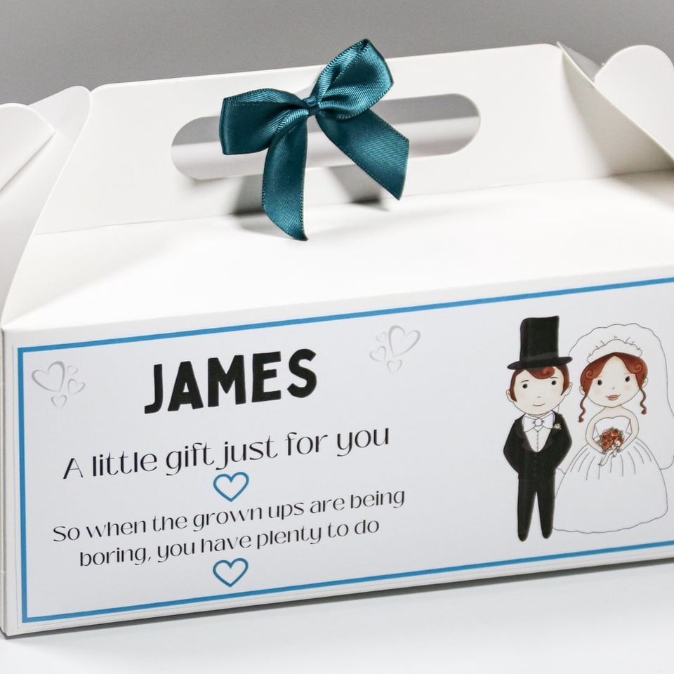 White gable box with a teal bow, labelled “James, a little gift just for you” with a bride and groom