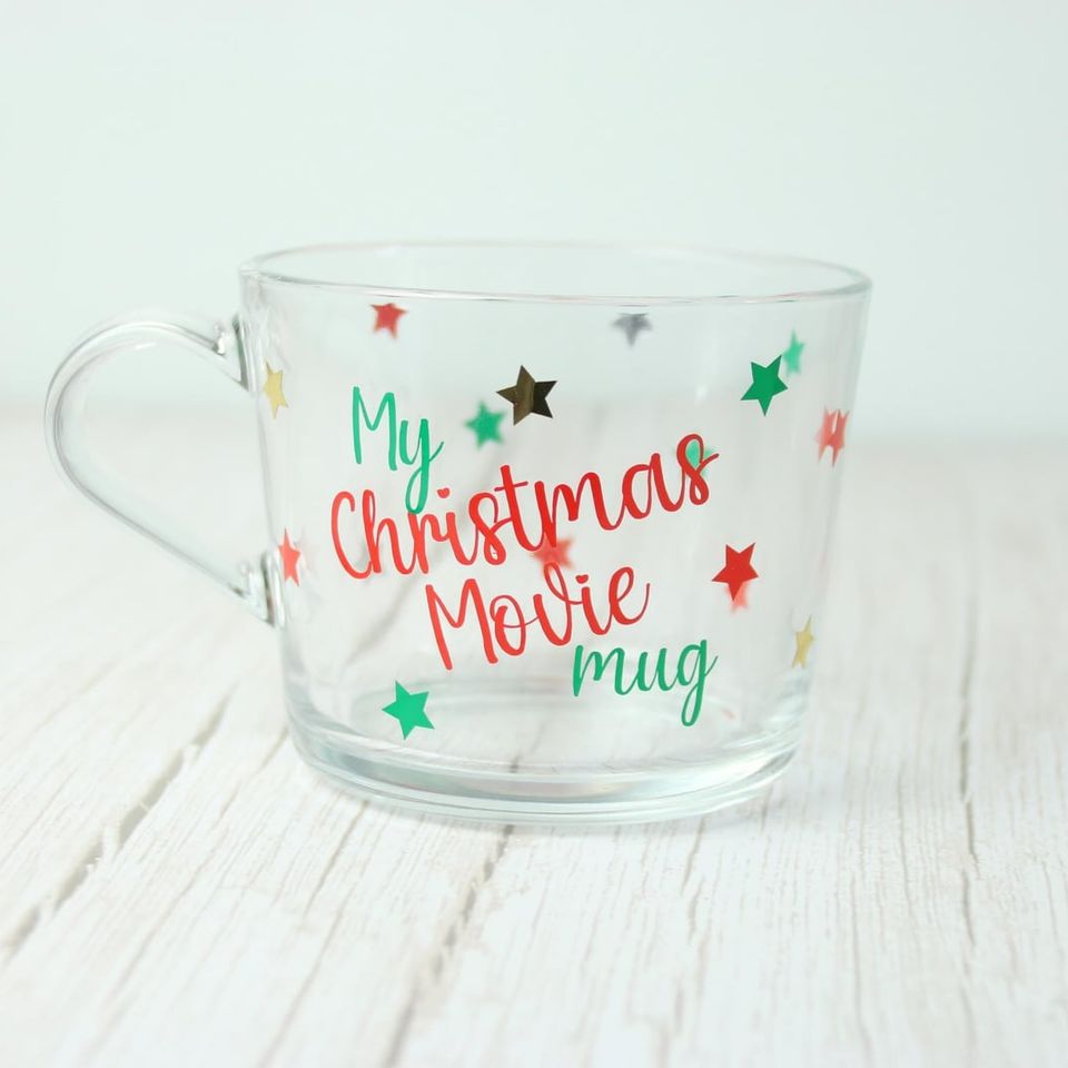 Clear glass mug lettered “My Christmas Movie Mug” with red, green and gold stars