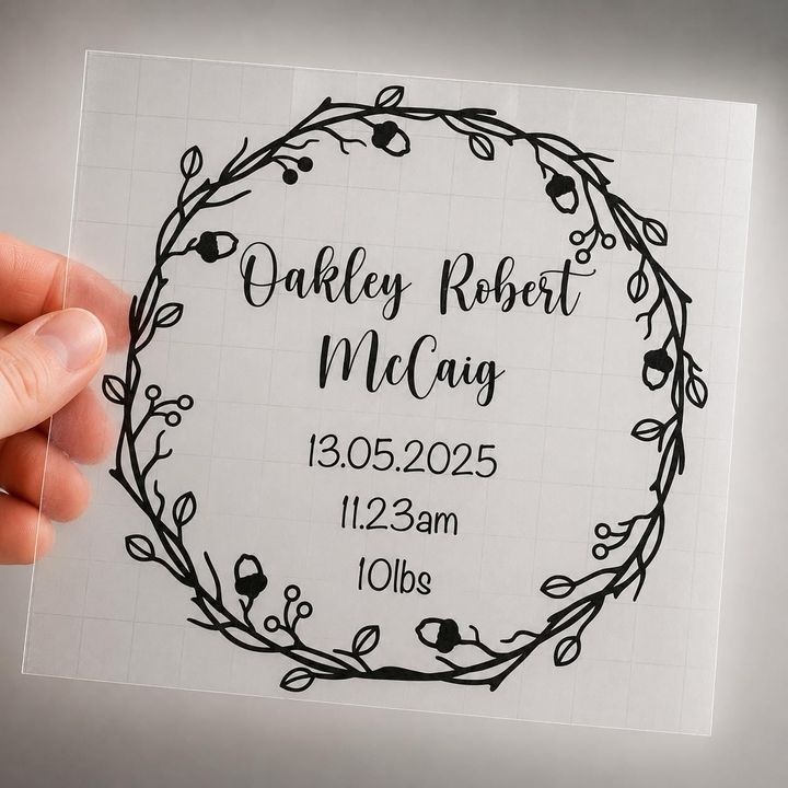 Clear vinyl decal with an acorn and berry wreath reading “Oakley Robert McCaig, 13.05.2025, 11.23am, 10lbs”