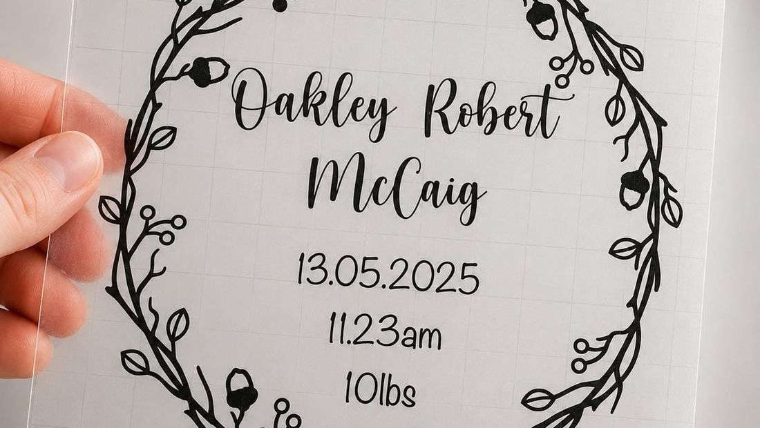 Clear vinyl decal with an acorn and berry wreath reading “Oakley Robert McCaig, 13.05.2025, 11.23am, 10lbs”