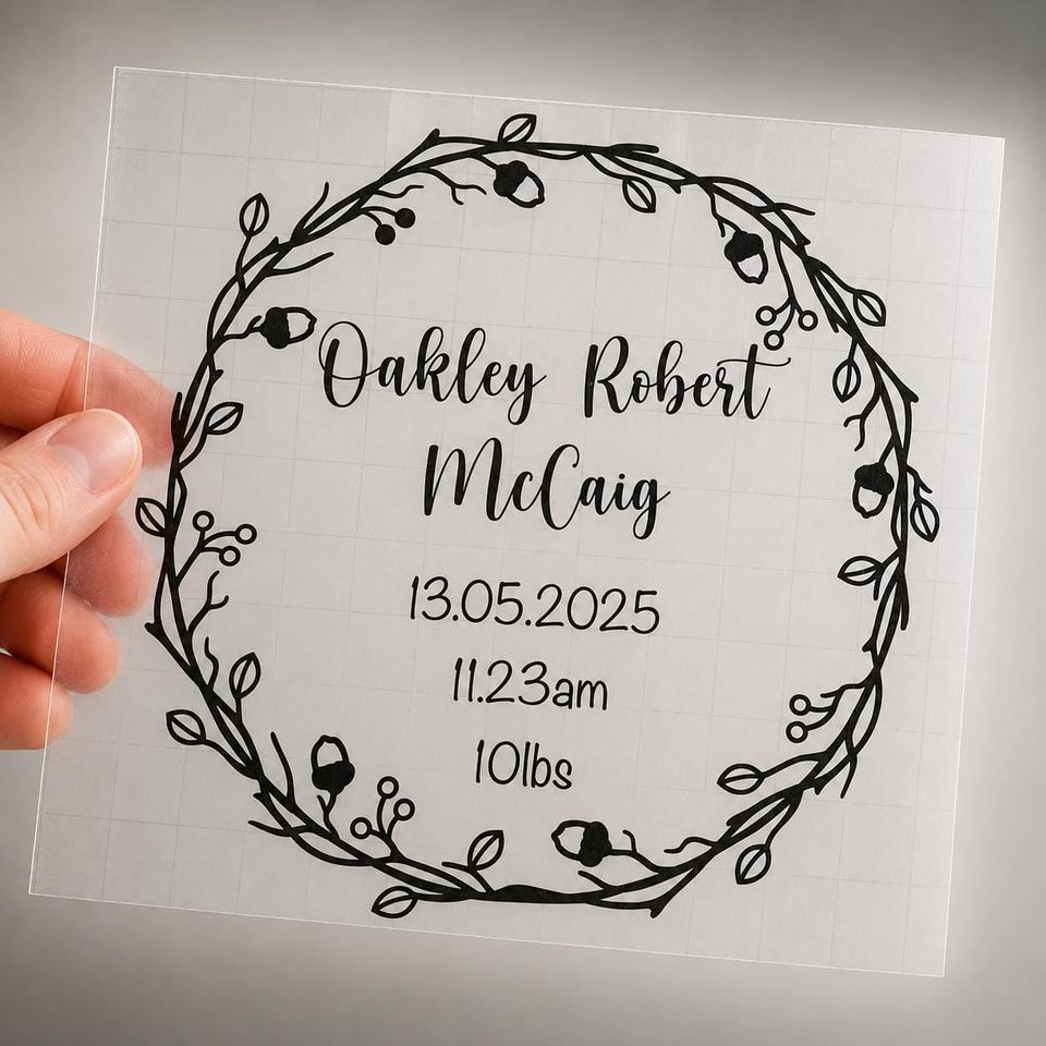 Clear vinyl decal with an acorn and berry wreath reading “Oakley Robert McCaig, 13.05.2025, 11.23am, 10lbs”